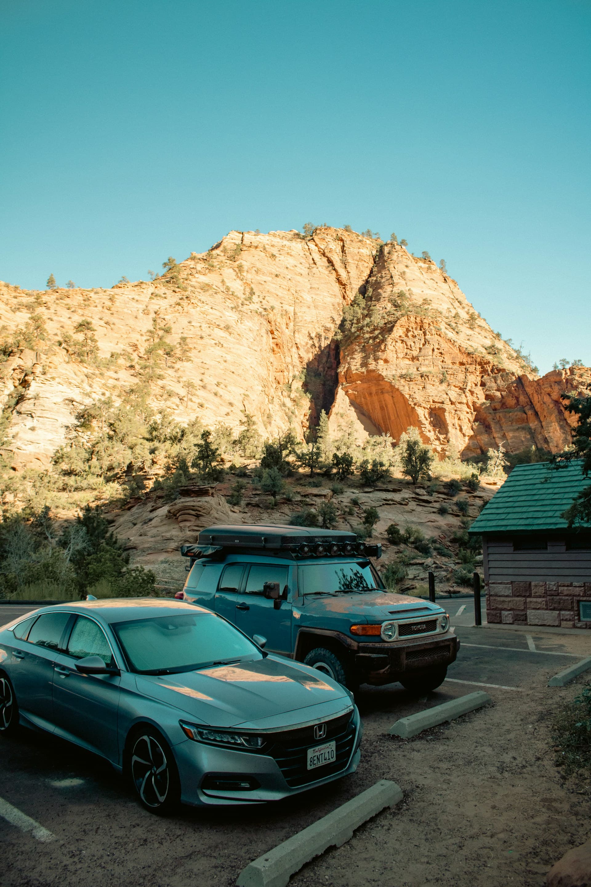 Two parked cars near sandstone cliffs